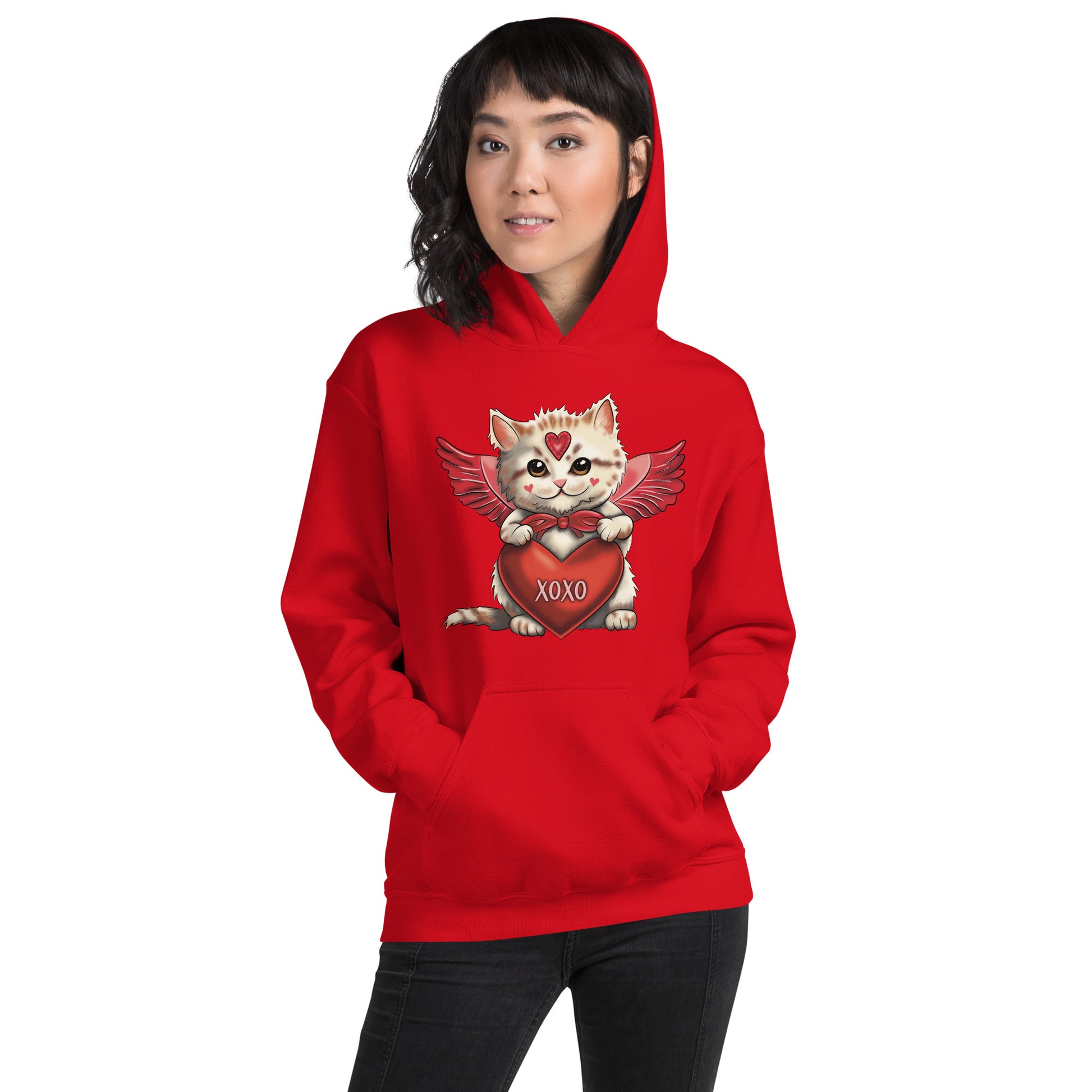 Pictured is a woman wearing a red hooded sweatshirt. The adorable design on the front of the hoodie is to be worn for Valentine's Day. Features an original illustration of a cute kitten dressed up as Cupid and holding a red heart that says "xoxo". This unique ladies clothing comes in 5  colors, red, pink, sport grey, sand, and white. Sizes available are small thru 5X.