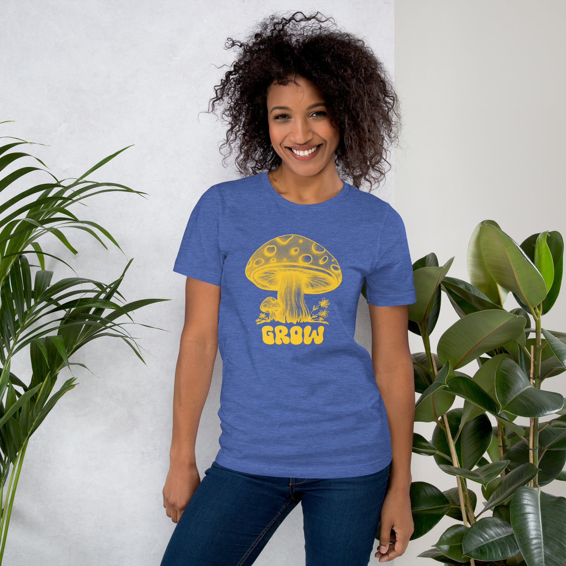 A female model wearing one of my cute mushroom designs on a blue t-shirt with yellow print. The design reads "GROW" in hippie style bubble lettering. The unique line sketched mushroom art and the comfort of this tee just might make it one of your favorite additions to your casual wardrobe. Several color options and plus sizes are available for this women's graphic tee.